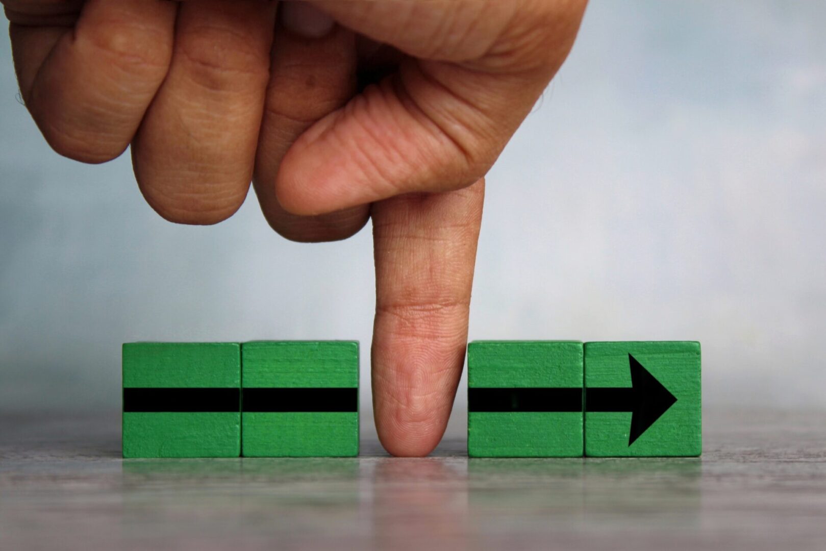 Finger divides the arrow cubes into two parts. Interruption, slowing down process, sabotage concept