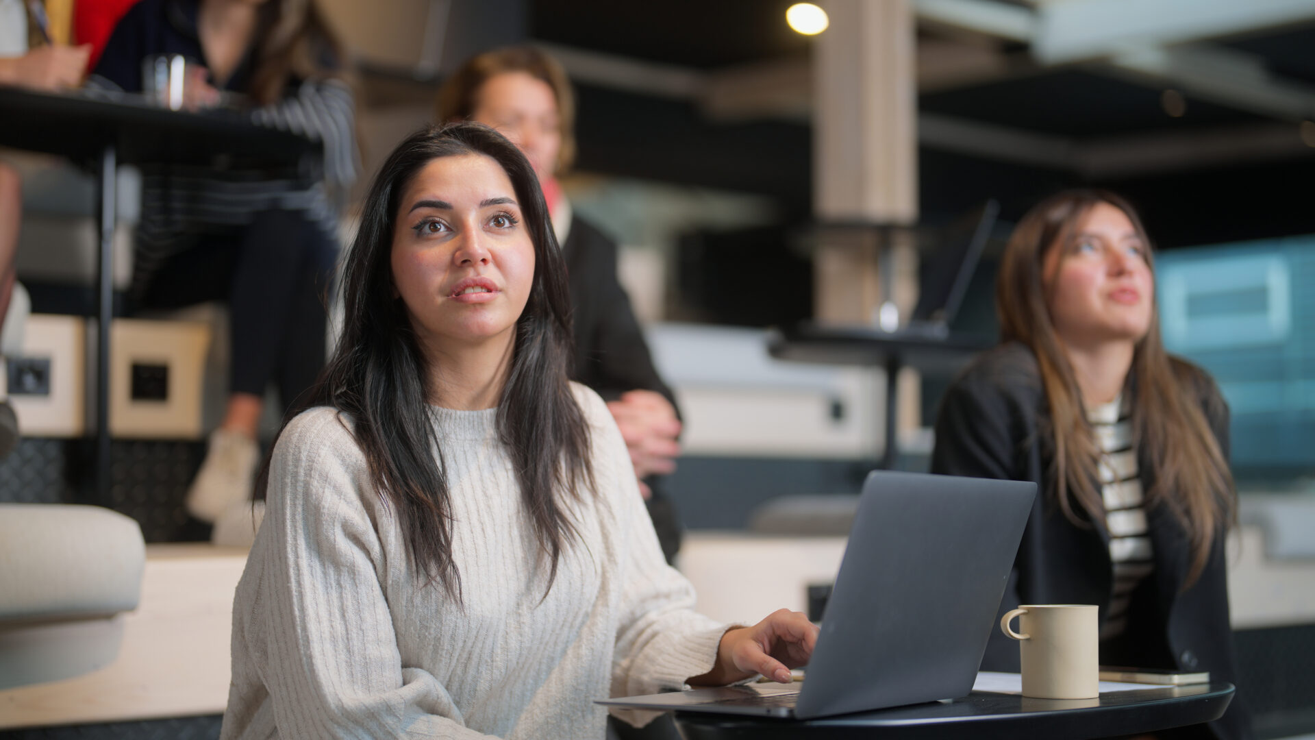 A group o young business people are joining a business conference and listening to the speaker.