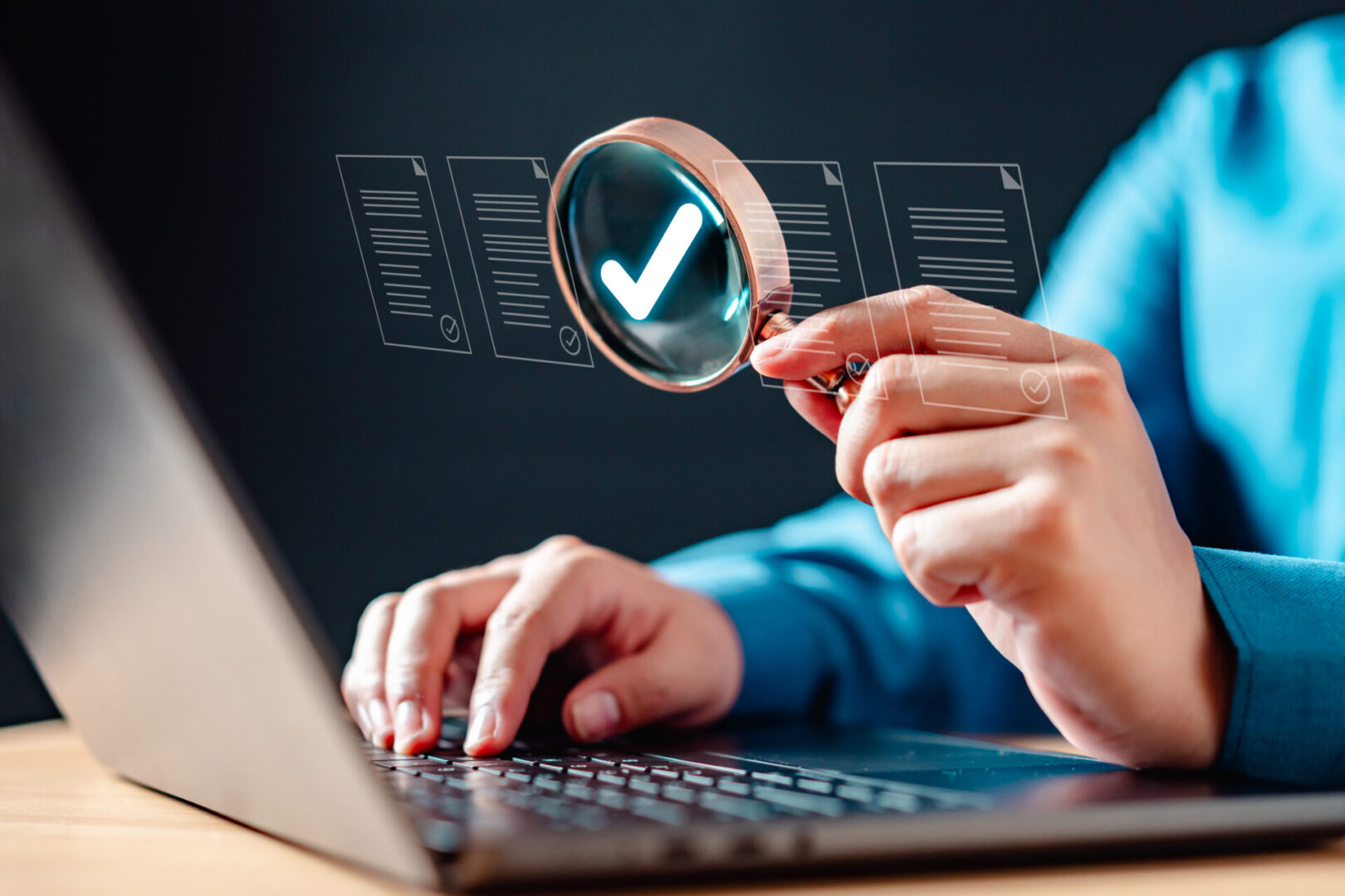 document, information, paper, text, examining, find, inspect, investigation, management, research. A person is using laptop with magnifying glass, on a document that is being checked.