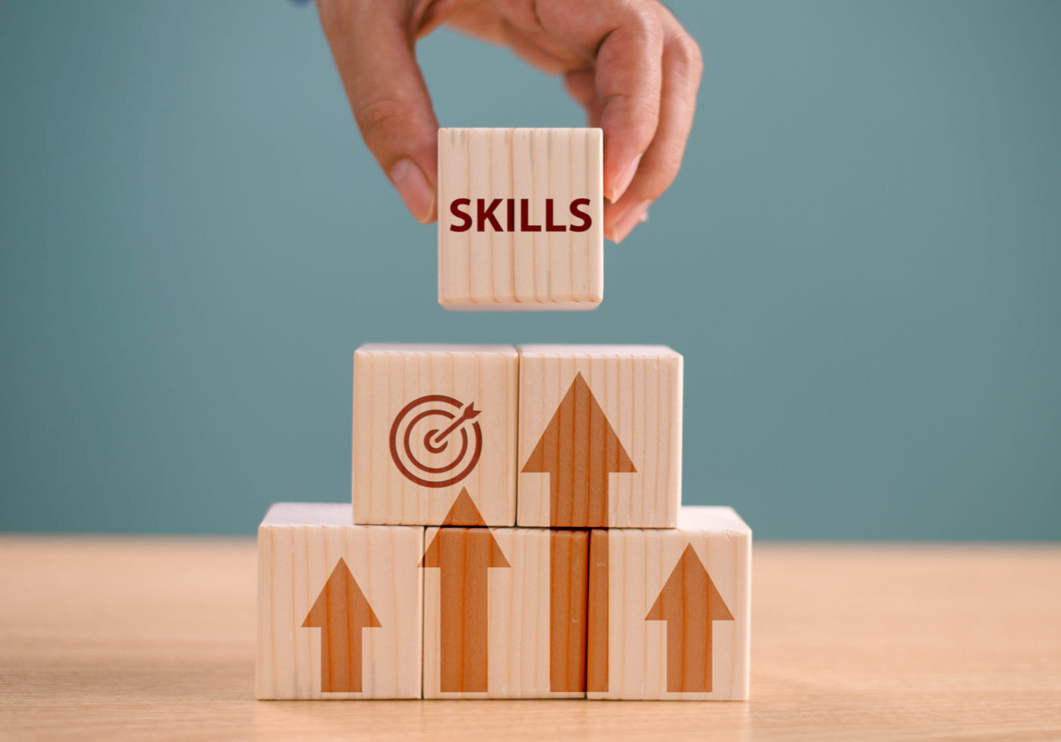Hand stacking skills block on wooden arrows.